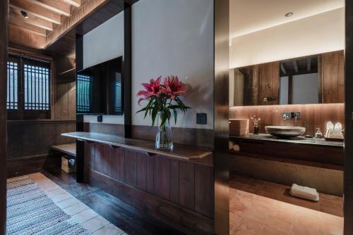 麗江的住宿－丽江古城安隅酒店，浴室里装有花瓶
