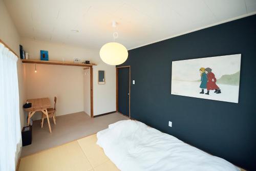 een slaapkamer met een bed en een schilderij aan de muur bij Aoyado - Tottori Aoya in Tottori