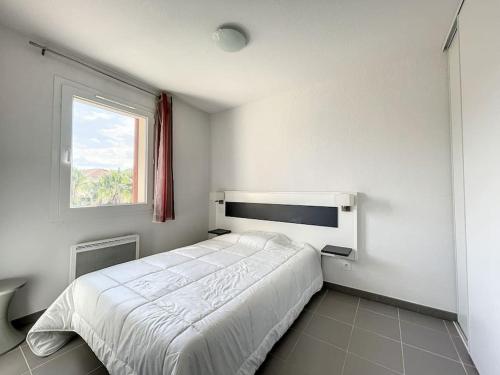 une chambre blanche avec un lit et une fenêtre dans l'établissement 3279-T3 dans une résidence avec piscine, à Argelès-sur-Mer