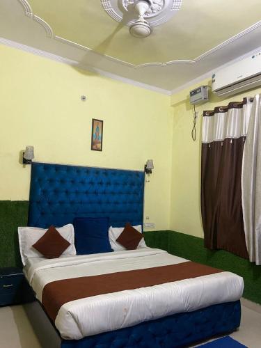 - un lit avec une tête de lit bleue dans l'établissement Ganga Vardan hotel, à Rishikesh