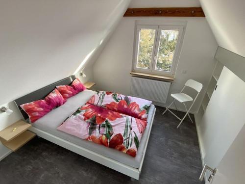 Un dormitorio con una cama con almohadas rosas y una ventana en Holiday apartment feel-good time, en Markdorf