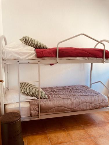 deux lits superposés dans une chambre avec un lit dans l'établissement Punta di Mare, appartements comme sur un bateau, à Linguizzetta