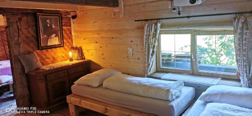 a room with two beds and a window in a log cabin at Kaiserlounge Harald Astner Ebbs in Ebbs