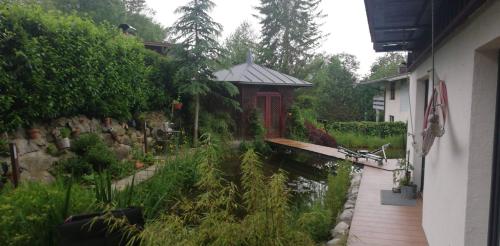 a garden with a wooden walkway next to a building at Kaiserlounge Harald Astner Ebbs in Ebbs