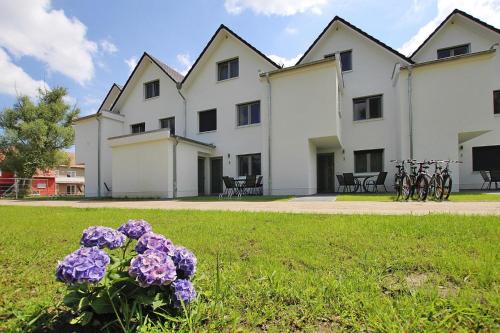 a large white building with purple flowers in the grass at Apartment Hafenflair am Plauer See Plau am See in Plau am See