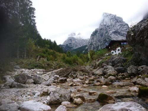 a river with rocks in front of a mountain at Kaiserlounge Harald Astner Ebbs in Ebbs