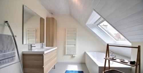 uma casa de banho com um lavatório, uma banheira e uma janela em Belle maison vue mer 5min de plage em Plouarzel