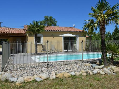 オリロルにあるCozy Villa in Sampzon with Swimming Poolのヤシの木と家のスイミングプール周囲の柵