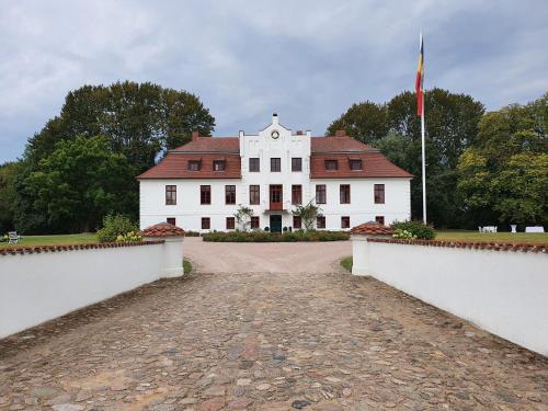 a large white house with a red roof at Historic Apartment in Gerdshagen with Garden in Gerdshagen