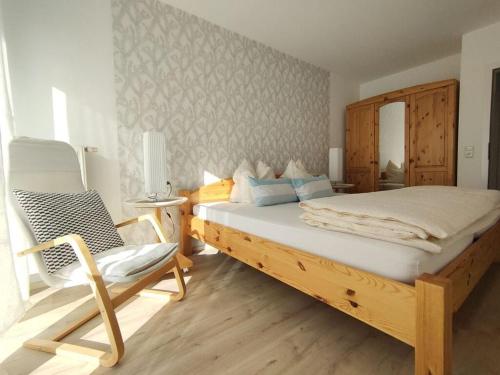 a bedroom with a large bed and a chair at Paradise in the paradise house in Sankt Englmar
