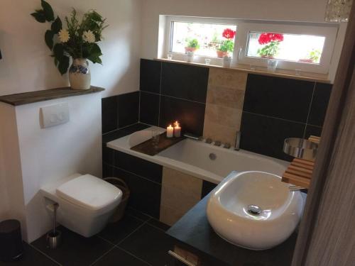 ein Badezimmer mit einer Badewanne, einem WC und einem Waschbecken in der Unterkunft Holiday apartment wellness & relaxation in Wunsiedel