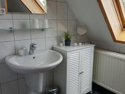 een witte badkamer met een wastafel en een spiegel bij Holiday apartment Aufderhaar in Ostbevern