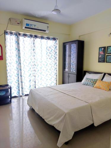 a bedroom with a large bed and a large window at 1 BHK Flat in Kochi 904 in Cochin