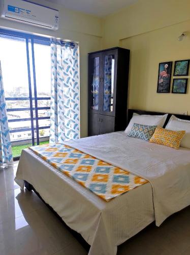 um quarto com uma cama grande e uma janela grande em 1 BHK Flat in Kochi 904 em Cochin
