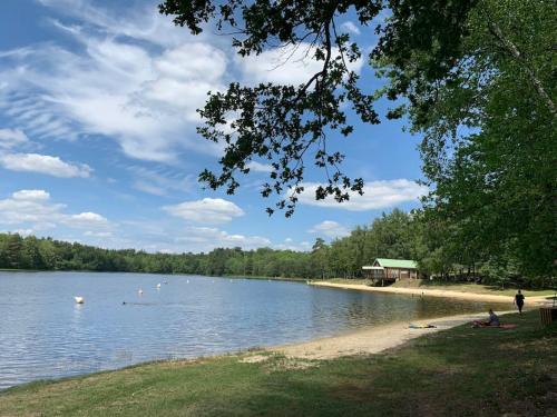 - une vue sur un lac avec des gens sur la rive dans l'établissement Le Petit Gîte de Milhac, à Milhac-de-Nontron