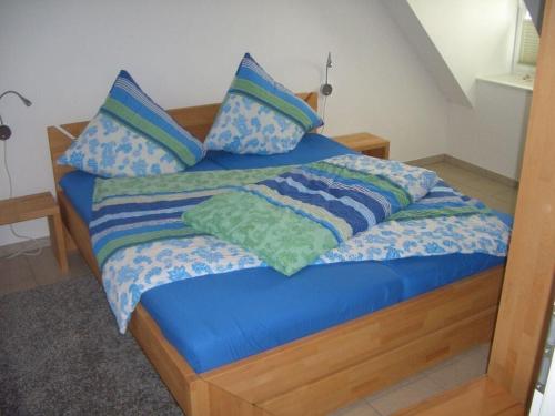 - un lit avec une couette et des oreillers bleus dans l'établissement Bird nest on the chestnut farm, à Pellworm