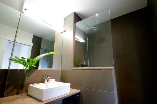 a bathroom with a sink and a mirror at Decô Apartments Barcelona-Diagonal in Barcelona