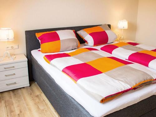 a large bed with colorful blankets and pillows on it at Apartment in Oberkirch in Oberkirch