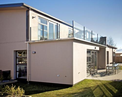 a large white house with a balcony at Apartments on Upton in Wanaka