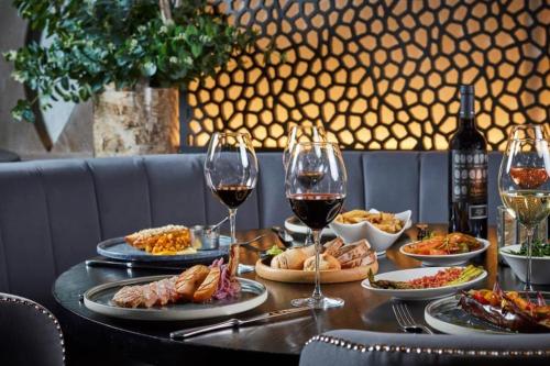 una tavola con piatti di cibo e bicchieri di vino di HEART of Birmingham-City Centre a Birmingham
