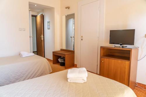 a hotel room with two beds and a flat screen tv at Four Seasons Hotel in Athens