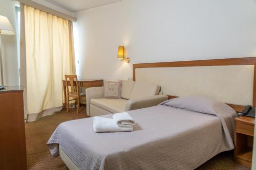 a hotel room with a bed and a couch at Four Seasons Hotel in Athens