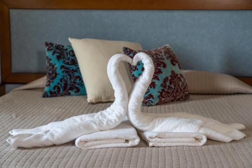 two towels shaped like swans sitting on a bed at Four Seasons Hotel in Athens