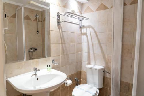 a bathroom with a white sink and a toilet at Four Seasons Hotel in Athens