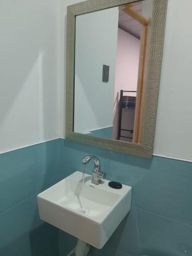 een witte wastafel in een badkamer met een spiegel bij Casa Hospedaje los Delfines en playa tortugas in Tortuga