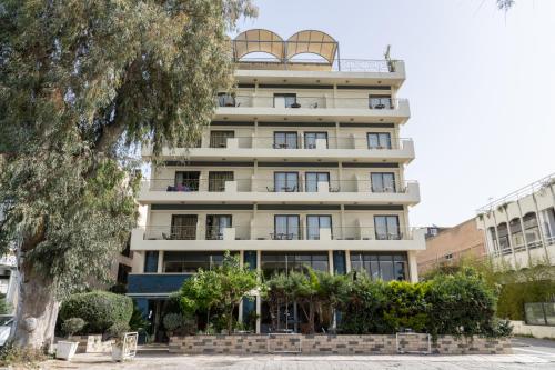 an apartment building with balconies and a tree at Four Seasons Hotel in Athens