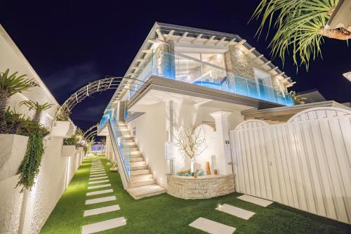 ein weißes Haus mit einer Treppe, die hinauf führt. in der Unterkunft Étoiles Luxury guest house Resort in Palmi