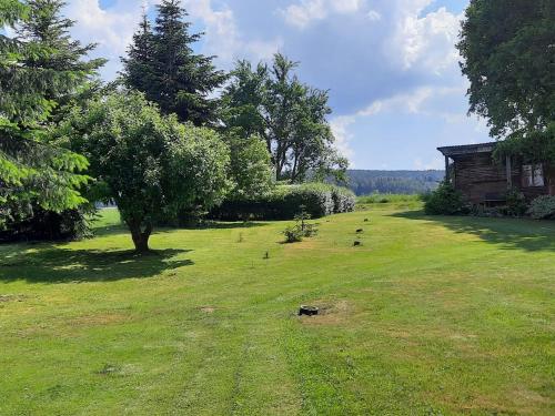 a grassy field with a house and a tree at Detached holiday home in an idyllic quiet location in Kleinwinklarn