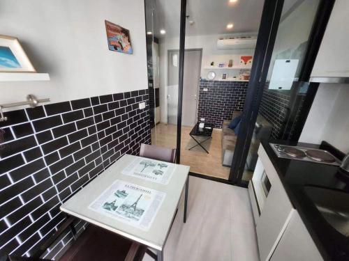 una pequeña cocina con mesa blanca y fregadero en 芭提雅双人精品公寓无边游泳池THEBASE中央基地, en Pattaya central