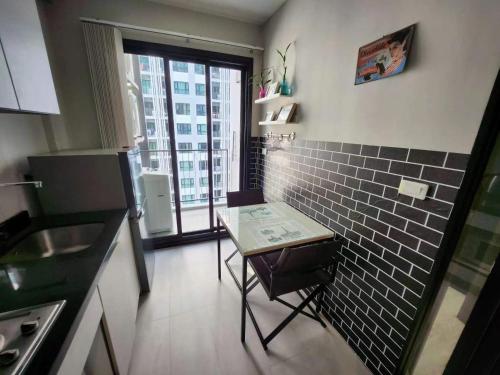 a small kitchen with a table and a window at 芭提雅双人精品公寓无边游泳池THEBASE中央基地 in Pattaya