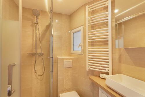 y baño con ducha, aseo y lavamanos. en Charmant studio tout confort, en París