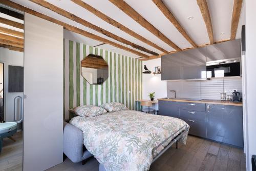 a bedroom with a bed and a kitchen at Charmant studio tout confort in Paris