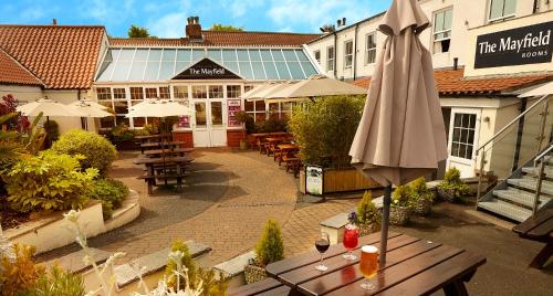an umbrella sitting on a table in front of a restaurant at The Mayfield Seamer in Scarborough