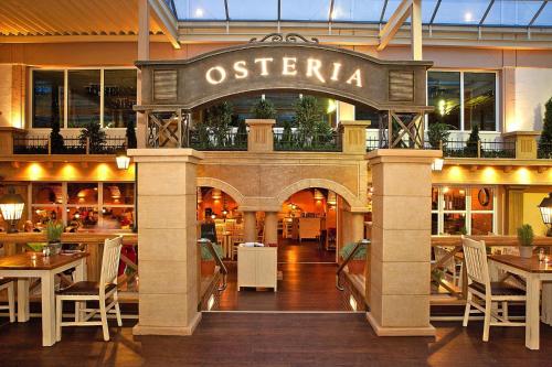 a restaurant with a sign that reads osteria at Semi detached houses in the Weissenh user Strand holiday and amusement park in Weissenhäuser Strand