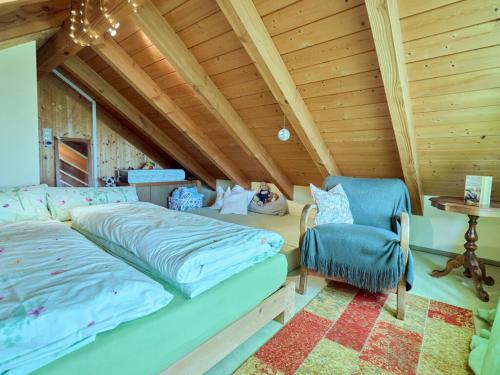 - une chambre mansardée avec un lit et une chaise dans l'établissement Holiday apartment Refugium Bühl, 