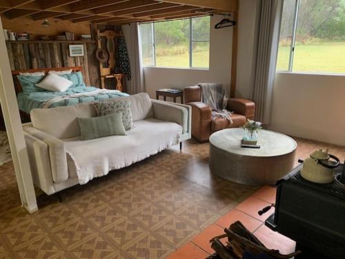 a living room with a couch and a bed at The Sanctuary Stanthorpe in Amiens