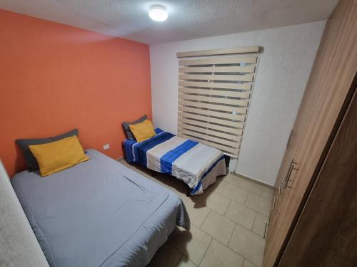 um quarto com 2 camas e uma janela em Departamento con Alberca San Jose em Querétaro