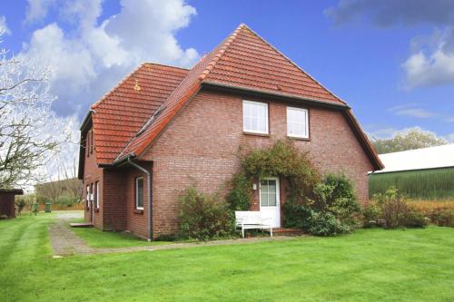 a red brick house with a bench in the yard at Apartment Garding in Garding