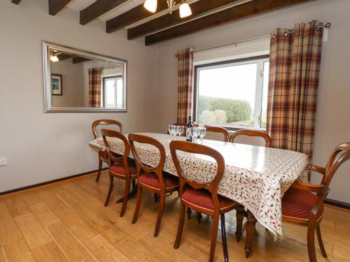 a dining room with a table and chairs and a window at Whitestacks in Bamburgh