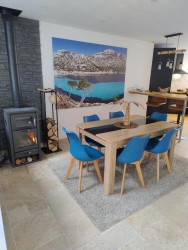 une salle à manger avec une table et des chaises et une cheminée dans l'établissement The Cosy House - votre havre de paix avec jardin privé, à Lisses