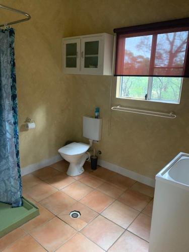 a bathroom with a toilet and a window at The Sanctuary Stanthorpe in Amiens
