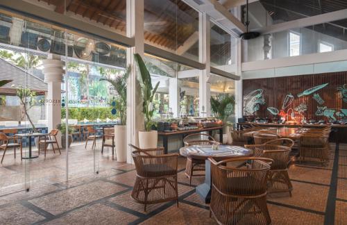 a restaurant with tables and chairs and windows at Montigo Resorts Seminyak in Seminyak