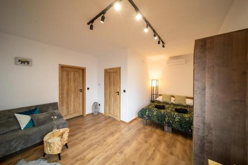 a living room with a couch and a bed at Czarni Górale in Barcice