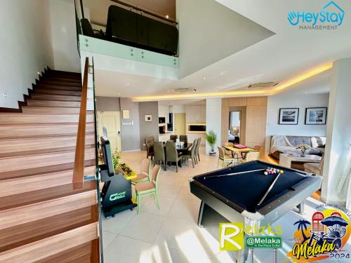 a living room with a pool table and a house at Atlantis Residences Melaka by HeyStay Management(2) in Melaka