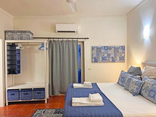 1 dormitorio con 1 cama con toallas en Casa Querida - Fuzeta, en Fuseta