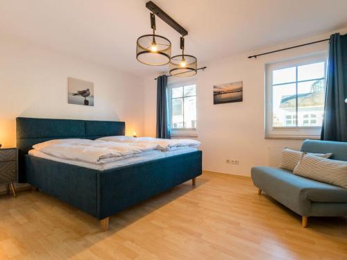 ein Schlafzimmer mit einem blauen Bett und einem blauen Stuhl in der Unterkunft Holiday apartment coastal love in Wustrow